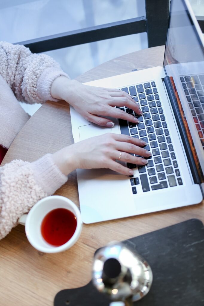 A woman is typing on her laptop