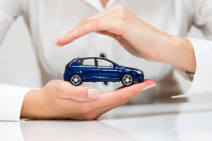 A woman safely holds a car toy in between her hands.