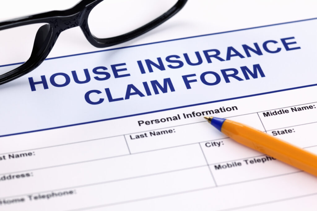 A House Insurance Claim Form with glasses and a pencil on the form.