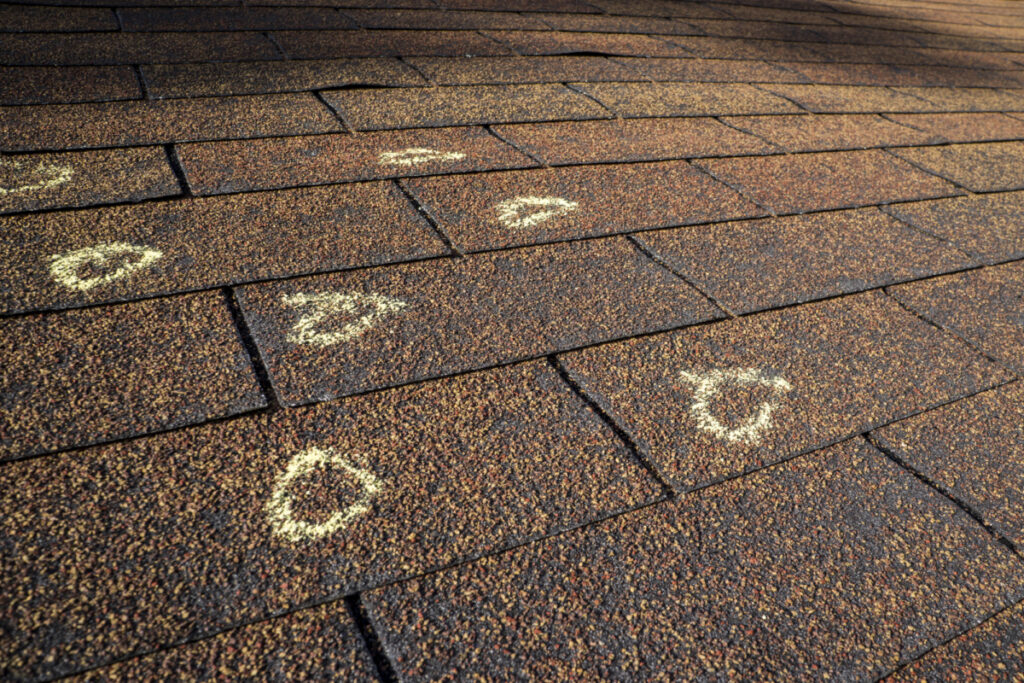 A roof that includes chalk outlines of where hail fell and caused damage.