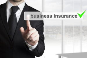 A person in a suit holds up his index finger and points at the "business insurance" check box with a green check mark to the right.