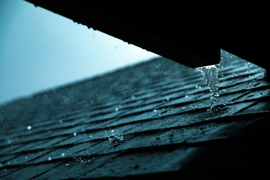A roof of a home experiences rain and hail.